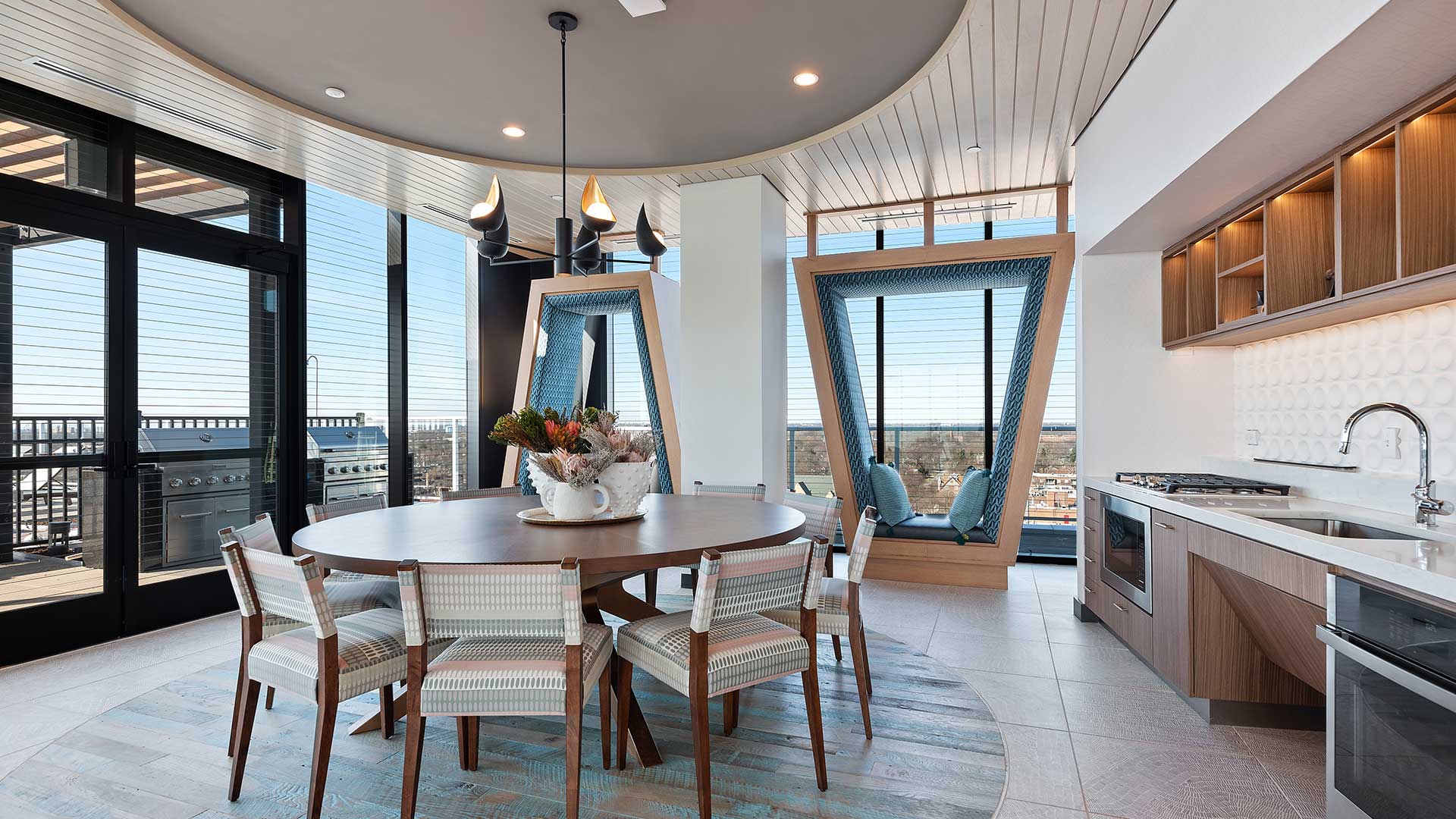 Eva Rooftop Sky Club kitchen and dining area with full-size appliances, communal table, window seating, and access to the rooftop terrace.