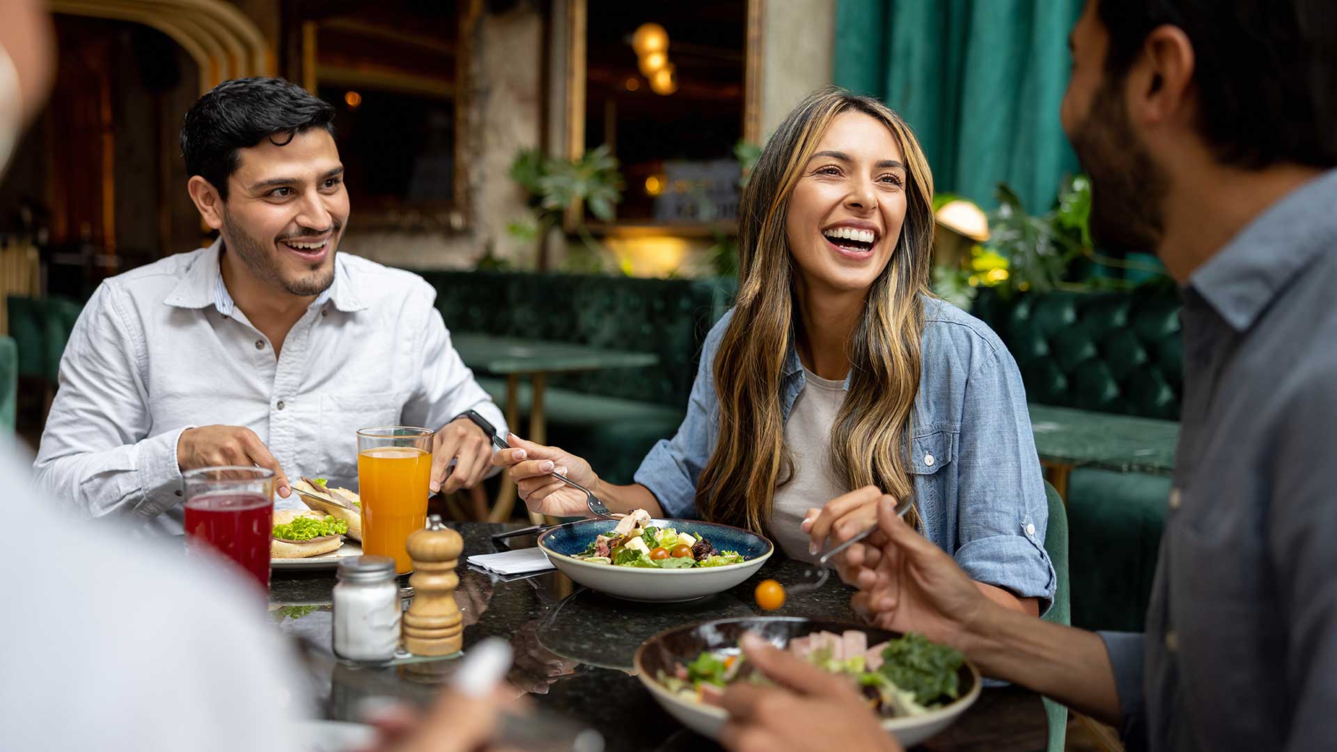 Group of friends sharing a meal and conversation at a restaurant.